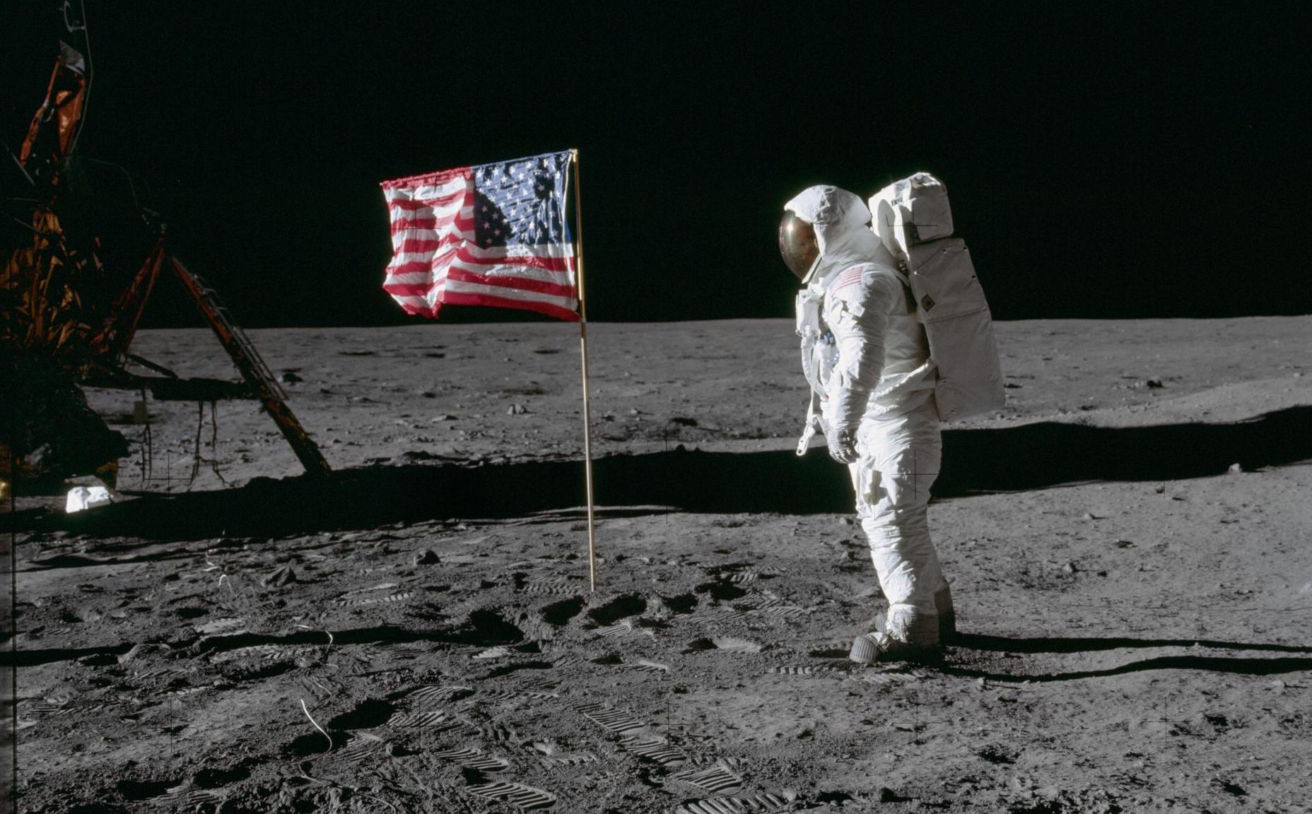 Apollo 11, an astronaut next to an American flag on the moon.